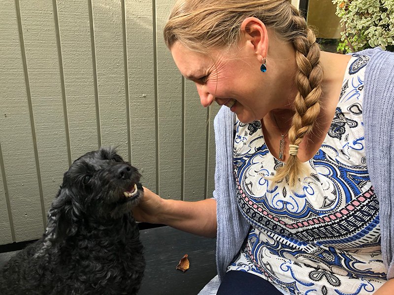 Lesley Huntley - Professional dog sitter in Christchurch petting a spoodle during a home visit